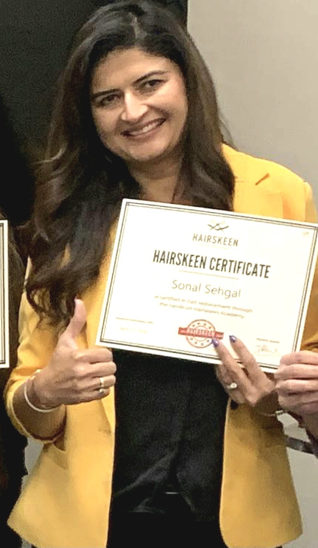 Sona holding her Hairskeen certificate